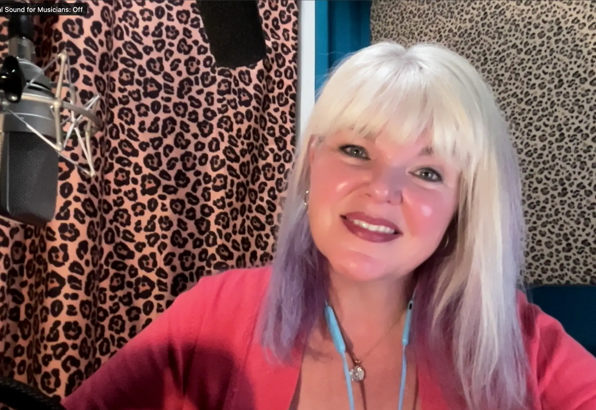 Victoria Prather a blond, blue eyed voice actor in her audio booth, smiles for the camera